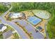 Beautiful aerial view showcasing a community pool, tennis courts, a pond, and surrounding greenery at 3825 Sycamore Hill Dr, Loganville, GA 30052