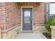 Inviting front door with glass window, set in brick with stone accents, offering curb appeal at 3825 Sycamore Hill Dr, Loganville, GA 30052