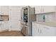 Modern kitchen with stainless steel refrigerator, white cabinets, and granite countertops at 3825 Sycamore Hill Dr, Loganville, GA 30052