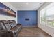 Cozy living room with wood flooring, large window, and plush leather seating at 3825 Sycamore Hill Dr, Loganville, GA 30052