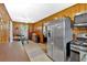Open kitchen area with wood paneling, dining space, and stainless steel appliances at 7783 Cantrell Rd, Douglasville, GA 30135