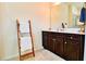 Bathroom featuring dark wood vanity with white countertop and decorative towel ladder at 165 Craines Vw, Covington, GA 30014