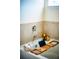 Close up of a soaking tub featuring a bamboo tray with bath accessories and tile surround at 165 Craines Vw, Covington, GA 30014