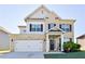 Charming two-story home features a brick facade, two-car garage, and meticulously maintained front yard at 165 Craines Vw, Covington, GA 30014