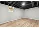 Finished basement area has a small window, light wood floors, and painted gray walls at 4170 Maroney Mill Rd, Douglasville, GA 30134