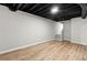 Basement rec room with light wood floors, black ceiling, and stairway to upper floors at 4170 Maroney Mill Rd, Douglasville, GA 30134