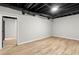 Finished basement space features light wood flooring, neutral gray walls, and black painted ceiling at 4170 Maroney Mill Rd, Douglasville, GA 30134