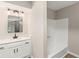 Bathroom features a modern vanity with stone countertops and shower-tub combo with bright white tile at 4170 Maroney Mill Rd, Douglasville, GA 30134