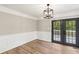 Elegant dining area with wood-look flooring, decorative molding, and stylish black French doors at 4170 Maroney Mill Rd, Douglasville, GA 30134