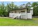 Attractive home with a white lattice-covered porch, complemented by a lush green lawn and mature trees at 4170 Maroney Mill Rd, Douglasville, GA 30134