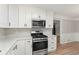 Well-lit kitchen features stainless steel appliances, modern white cabinets, granite countertops, and plank flooring at 4170 Maroney Mill Rd, Douglasville, GA 30134