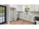 Contemporary kitchen with white cabinets, stainless steel appliances, and convenient outdoor access at 4170 Maroney Mill Rd, Douglasville, GA 30134
