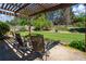 Relaxing backyard patio with pergola overlooking the spacious lawn and fenced yard at 7095 Valley Landing Ct, Cumming, GA 30041