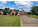 Charming brick home featuring a manicured lawn and long driveway on a sunny day at 7095 Valley Landing Ct, Cumming, GA 30041