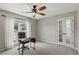 Cozy home office space with large window for natural light and a ceiling fan at 7095 Valley Landing Ct, Cumming, GA 30041