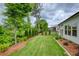 Spacious backyard showcasing a manicured lawn, lined with mulch and diverse plants at 714 Chipping Sparrow St, Canton, GA 30115