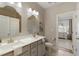 Bathroom featuring double sinks with stone countertops and an open view to the bedroom at 714 Chipping Sparrow St, Canton, GA 30115