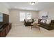Cozy living room with a large sectional sofa, a wooden coffee table, and neutral carpeting at 714 Chipping Sparrow St, Canton, GA 30115