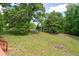 Backyard featuring a grassy lawn and a swing set surrounded by lush trees at 17 Hiram Way, Hiram, GA 30141