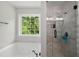 Bright bathroom with a soaking tub, glass shower, and a window offering natural light and garden views at 17 Hiram Way, Hiram, GA 30141
