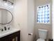 Charming half bath with a round mirror, white sink, and patterned wallpaper at 17 Hiram Way, Hiram, GA 30141