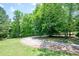 Driveway view showing lush greenery, with trees, and a red barn at 17 Hiram Way, Hiram, GA 30141