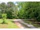 Gravel driveway leads through a green lawn and mature trees at 17 Hiram Way, Hiram, GA 30141
