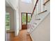 Bright foyer showcases wood floors, staircase with white railings, and a view of the front doors at 17 Hiram Way, Hiram, GA 30141