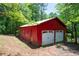 A two-car red garage with white doors and a covered area sits surrounded by trees at 17 Hiram Way, Hiram, GA 30141