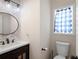 Stylish powder room featuring patterned wallpaper, oval mirror, and a window at 17 Hiram Way, Hiram, GA 30141