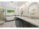 Modern bathroom featuring a soaking tub, double vanity with granite countertops, and updated fixtures at 194 Beaverwood Ct, Lawrenceville, GA 30044