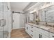 Beautiful bathroom with dual vanities, granite countertops, a barn door, and modern fixtures at 2470 Crimson Downs Dr, Cumming, GA 30040