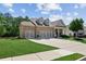 Charming brick home featuring a three-car garage, well-manicured lawn and inviting curb appeal at 2470 Crimson Downs Dr, Cumming, GA 30040