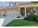 Inviting front of a brick home with a three-car garage, covered porch and nicely landscaped yard at 2470 Crimson Downs Dr, Cumming, GA 30040