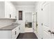 Brightly lit hallway featuring white cabinets and access to laundry room and other rooms at 2470 Crimson Downs Dr, Cumming, GA 30040