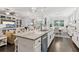 Kitchen featuring a spacious island with seating, white cabinets, and an open layout connecting to the living room at 2470 Crimson Downs Dr, Cumming, GA 30040
