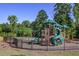 A playground with swings, slides, and climbing structures is enclosed by a black metal fence for safety at 2470 Crimson Downs Dr, Cumming, GA 30040