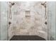 Luxurious shower features dual shower heads, marble tile, and built-in niches for a spa-like experience at 2470 Crimson Downs Dr, Cumming, GA 30040