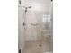 Tiled shower with glass door, multiple shower heads, and built-in seat at 2470 Crimson Downs Dr, Cumming, GA 30040