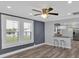 Open-concept living room with wood floors, ceiling fan, and large windows providing natural light at 3049 Highway 411 Ne, White, GA 30184