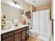 Well-lit bathroom with a shower, toilet, and vanity with dark wood cabinets at 4590 Hastings Dr, Cumming, GA 30041