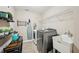 Laundry room with large washer and dryer, utility sink, and shelving at 4590 Hastings Dr, Cumming, GA 30041