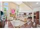 Open-concept living room with a stone fireplace, hardwood floors, and a view of the kitchen at 4590 Hastings Dr, Cumming, GA 30041