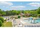 Community pool area with tables, lounge chairs, and colorful mushroom water features, surrounded by lush landscaping at 4590 Hastings Dr, Cumming, GA 30041