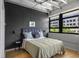 Relaxing bedroom with industrial ceilings, hardwood floors, and a scenic view from the windows at 878 Peachtree Ne St # 431, Atlanta, GA 30309