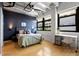 Comfortable bedroom featuring an industrial ceiling, hardwood floors, and natural light from the windows at 878 Peachtree Ne St # 431, Atlanta, GA 30309