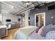 Spacious bedroom featuring industrial ceilings, wood floors, and an open view into the living room and kitchen at 878 Peachtree Ne St # 431, Atlanta, GA 30309