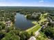Overhead view of a community featuring a lake, golf course, and neighborhood homes surrounded by trees at 210 Wentworth Ter, Alpharetta, GA 30022