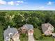 Wide aerial view showcases stately brick home exteriors surrounded by lush greenery and mature trees at 210 Wentworth Ter, Alpharetta, GA 30022