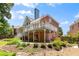 Rear exterior view of home featuring a deck, patio, and landscaped yard at 210 Wentworth Ter, Alpharetta, GA 30022